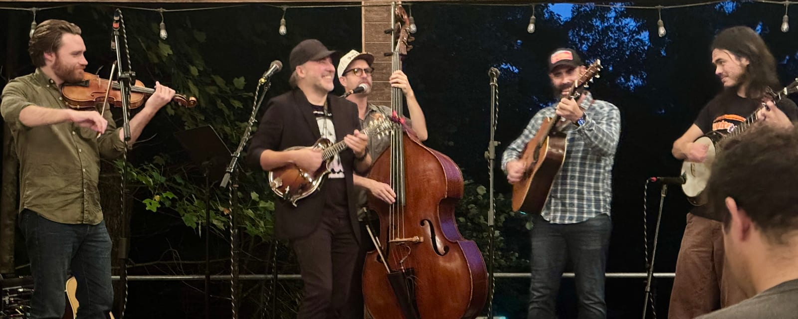 Five bluegrass musicians performing at the Woodshed Guitar Experience