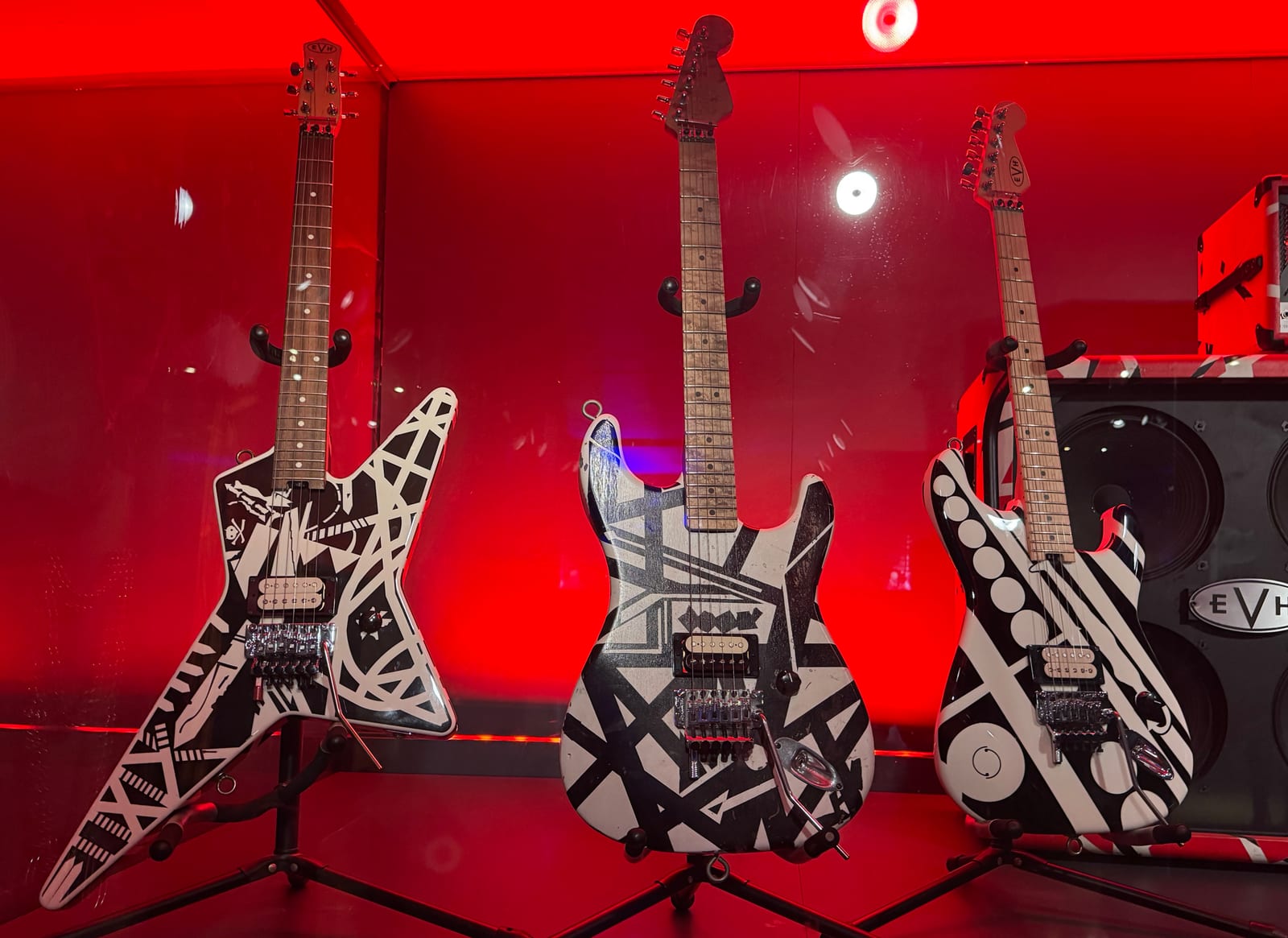 Three Eddie Van Halen striped guitars in a museum display